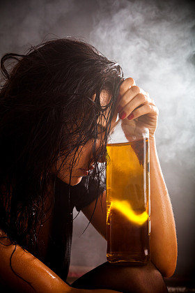 美丽的女人用的酒精饮料瓶的肖像