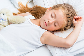 在白色的床上睡觉的小女孩图片