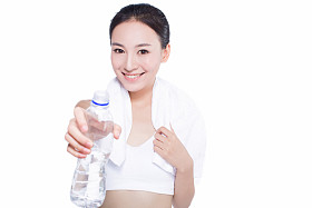 健康的亚洲女性，用毛巾和矿泉水瓶