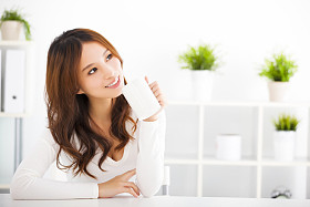 幸福的亚洲年轻女人喝咖啡图片
