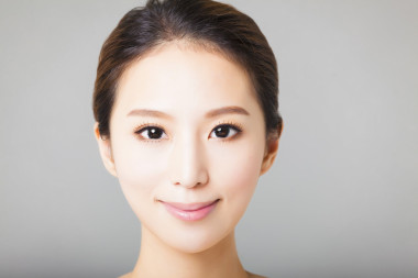 微笑的年輕漂亮的亞洲女人臉的特寫 
