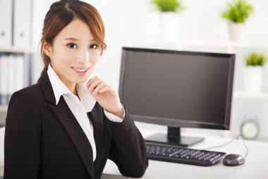 愉快的年輕商業(yè)女人在辦公室工作