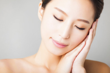 微笑的年輕漂亮的亞洲女人臉的特寫 