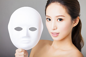 年轻女子捧着白色面具的医疗美容概念