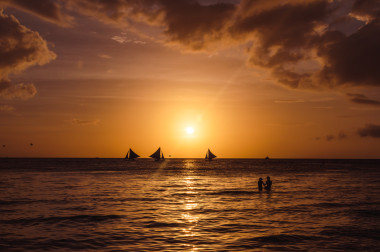 帆船和夫妇反对一个美丽的黄昏剪影