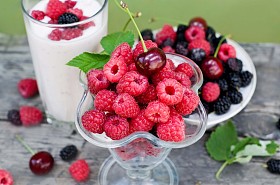 覆盆子、 樱桃和桑葚的绿色背景