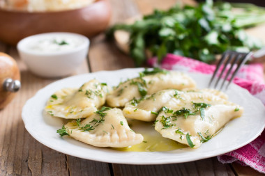 斯拉夫菜傳統(tǒng)菜。木制的桌子上的白板上的馬鈴薯填充 varenyky