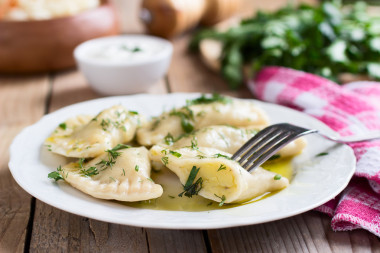 斯拉夫菜傳統(tǒng)菜。木制的桌子上的白板上的馬鈴薯填充 varenyky