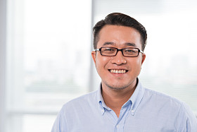 在眼镜的越南男人微笑