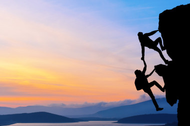 兩個男人旅行聯(lián)合工作團(tuán)隊(duì)在登山團(tuán)隊(duì)，美麗的日落景觀互相幫助