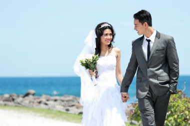 新郎和新娘走手牽手在海邊