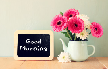 黑板上用句早上好寫在它旁邊用鮮花的花瓶