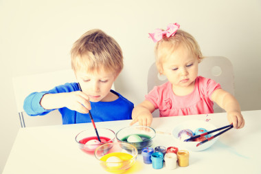 复活节小男孩和蹒跚学步的女孩画鸡蛋