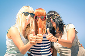 Groups of young girlfriends focus on colorful funny hair and sunglasses - summer expressions of friendship and fun with thumbs of positivity -- best friends sharing the concept of happiness together