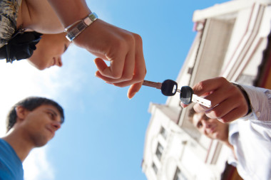 在現(xiàn)代的一家人房子前對(duì)年輕夫婦的肖像