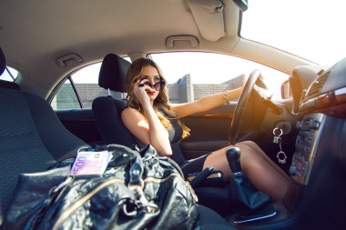 好年輕成人金發(fā)女孩開車與包的藍(lán)眼睛