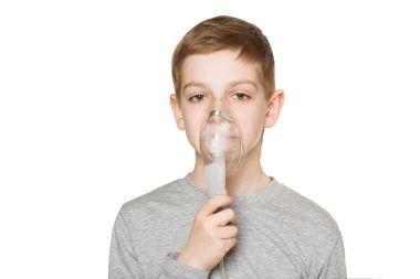 通過吸入器面罩上 w 孤立呼吸一個男孩的肖像