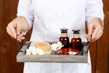 美容治療師拿著托盤(pán)的水療，特寫(xiě)，木墻背景