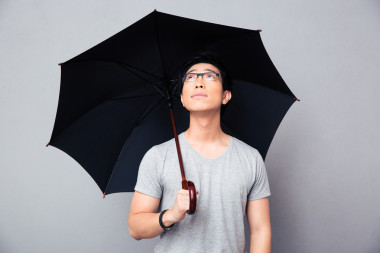 亞洲人站在一起的雨傘，望著圖片