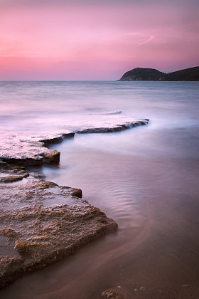 Baratti 湾，岬角山、 岩石和海上日落。托斯卡纳，它