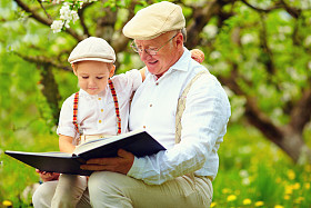 祖父与孙子读书在春天的花园