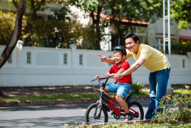 男子教学儿子骑自行车
