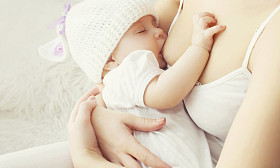 软照片母亲喂养母乳宝宝在家里 