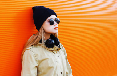 漂亮的金發(fā)，戴著一頂黑色的帽子和耳機(jī)聽(tīng) musi