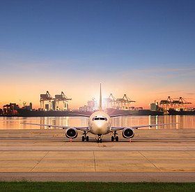 货运飞机停车在机场跑道和航运港口背后 