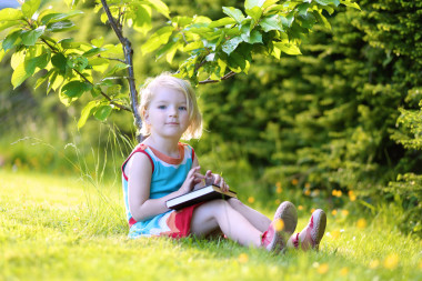 在公園里的智能學(xué)齡女孩閱讀書
