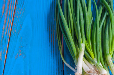 葱也称为沙拉洋葱、 葱或葱蓝色木桌上。与自由文本空间的乡村背景
