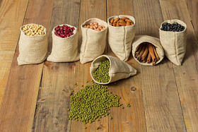 不同种类的豆子和桂皮中的木制背景上塑袋