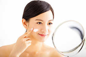 女人应用霜洗脸上的微笑图片
