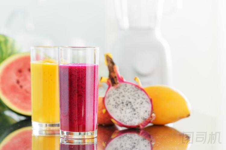 新鮮的果汁，在廚房的桌子上。攪拌機(jī)在背景中