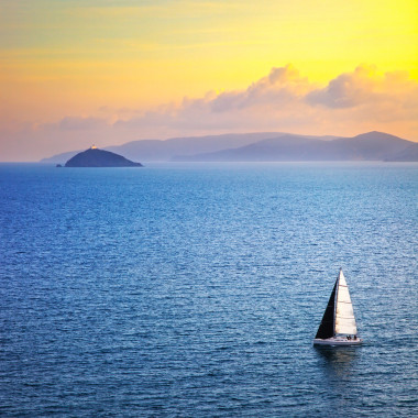 厄爾巴島日落美景從昂只揚帆的船。地中海