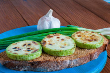 打開三明治配黃油、 烤的西葫蘆和蔥在農(nóng)村或鄉(xiāng)村廚房在從上面的老式木桌子。選擇性的焦點