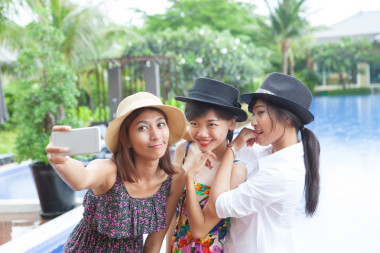 通過智能手機的年輕亞裔女子拍照肖像使用