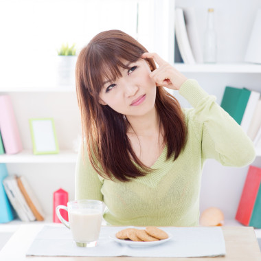 亞洲女孩一邊吃早餐一邊思考