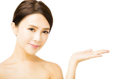 美麗的年輕女子顯示美容產(chǎn)品空在手