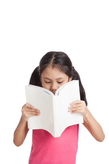 快樂的亞洲小女孩在看書