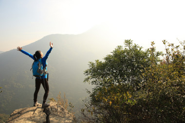 女人名徒步旅行者在山的頂峰圖片