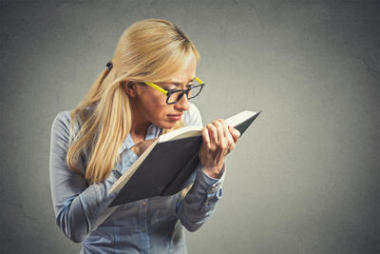 戴眼鏡的女人試著看書(shū)視力不好