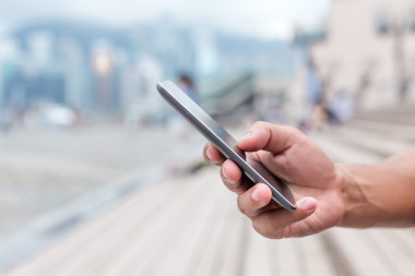 手拿着手机在街上图片