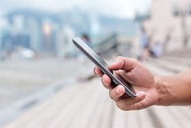 手拿着手机在街上图片