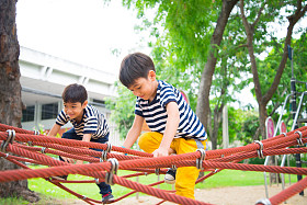 小男孩爬绳子在操场上图片