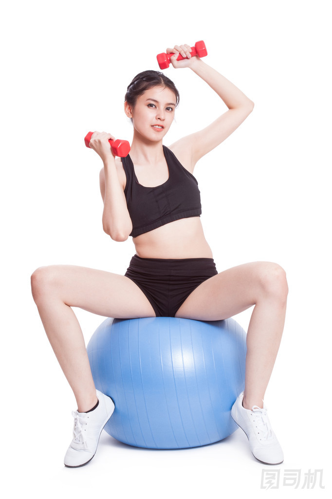 健身女人運動訓(xùn)練與練習(xí)球和舉重