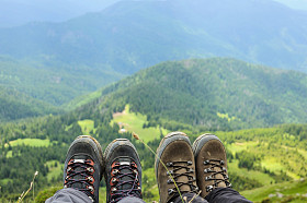 旅行者坐在高山顶上的登山靴