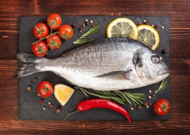 新鮮的魚、 檸檬、 香料和西紅柿在板上