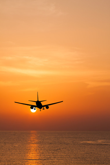 飛過海在日落時的剪影商用飛機(jī)