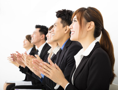 商务人士坐在一排，鼓掌喝彩图片